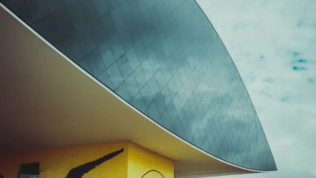 The curved underside of the Oscar Niemeyer Museum against a pale sky
